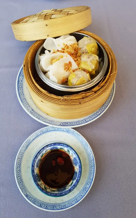 Panier vapeur en bambou garni de raviolis et sauce soja