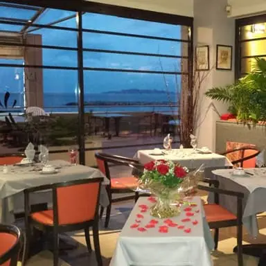 Salle dressée face aux baies vitrées et à la mer